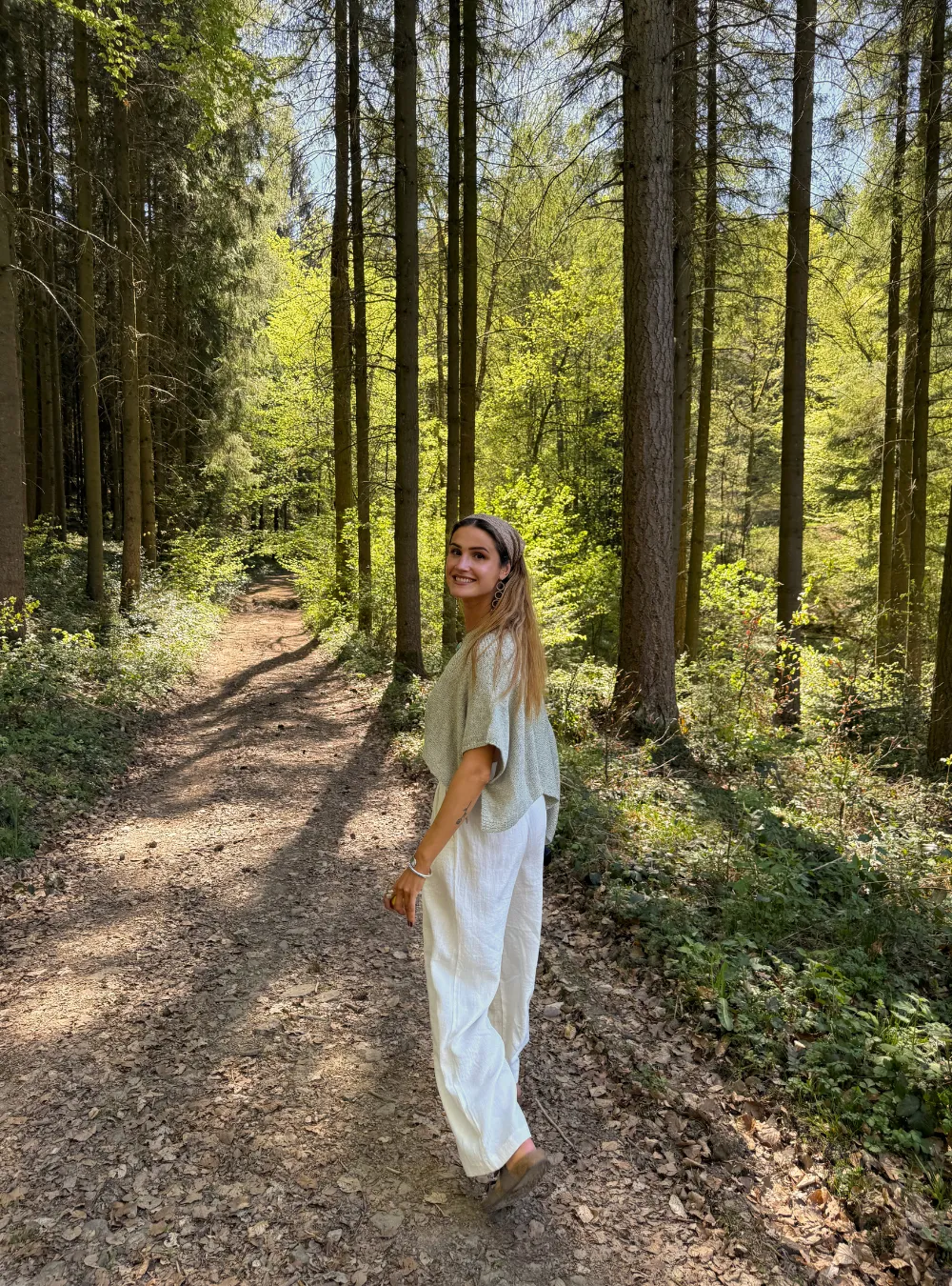 Mirthe wandelt door een zonovergoten bos