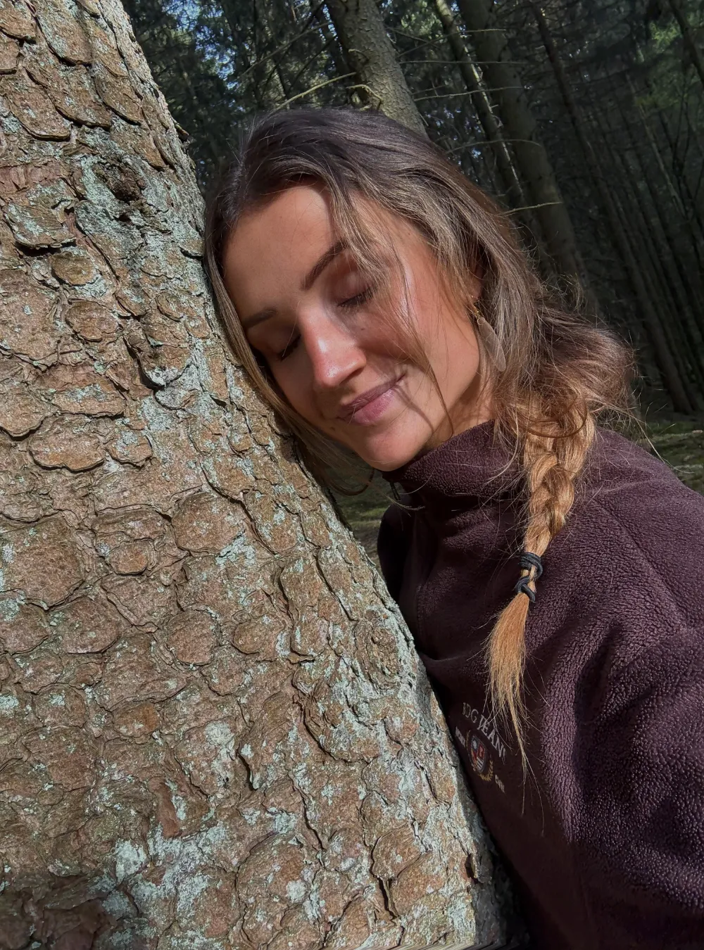 Een rustig moment in het bos, ogen gesloten tegen een boomstam